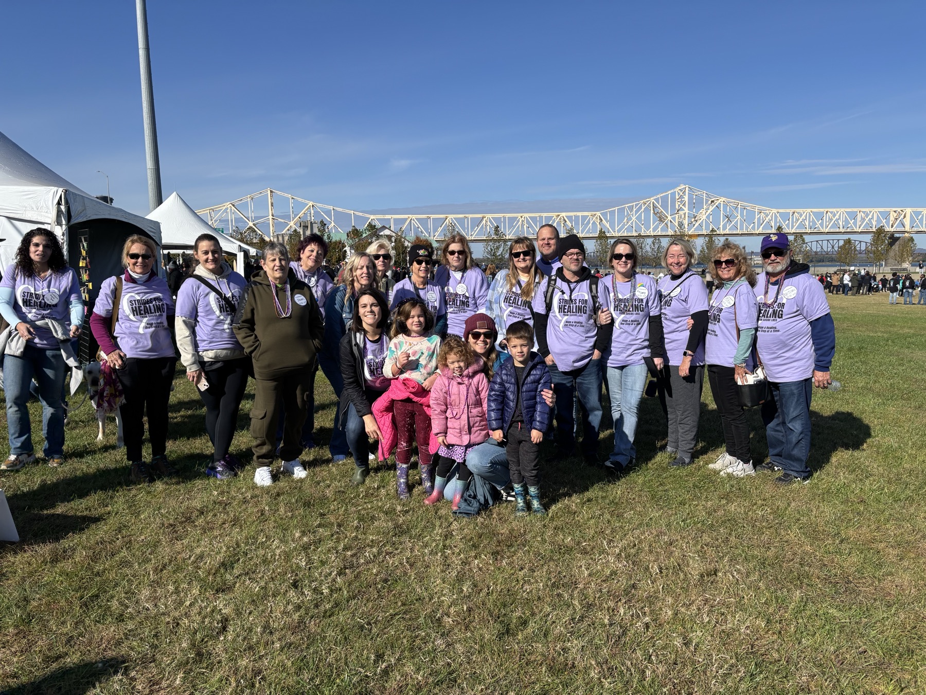 Strides for Healing team members gathered at Waterfront Park in purple team shirts